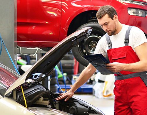 employee working on engine with handbook